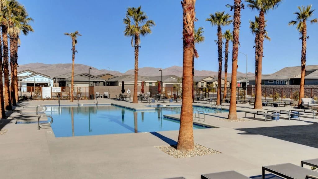 Resort pool with palms and mountain views at Del Webb North Ranch in North Las Vegas